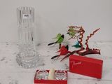 un vase en verre, un bougeoir et une boîte posés sur une table