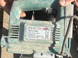 a person using a corded jig saw to cut a piece of wood
