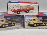 three boxed boxed toys of trucks are sitting on a white surface