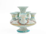 a vase that has five cups on top of it