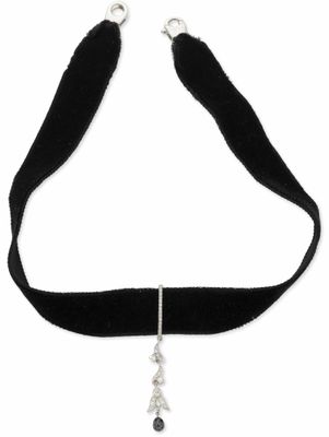 un gros plan sur un collier ras-du-cou noir orné d'une breloque en argent