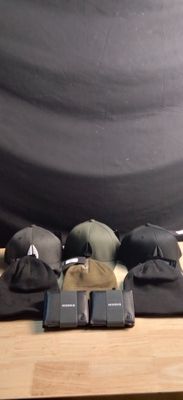 several hats are sitting on a wooden table with a black backdrop in the background
