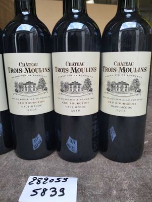 four bottles of red wine on a table with a price tag