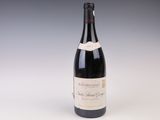 an old bottle of wine sitting on top of a white table