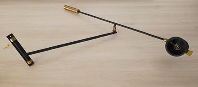 une photo d'une horloge noire et dorée posée sur une table en bois