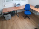 a blue office chair sitting in front of a computer desk