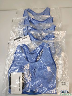trois paires de t-shirts bleus emballés dans du plastique, posés sur une table