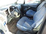 the interior of a small car with blue seats and a steering wheel