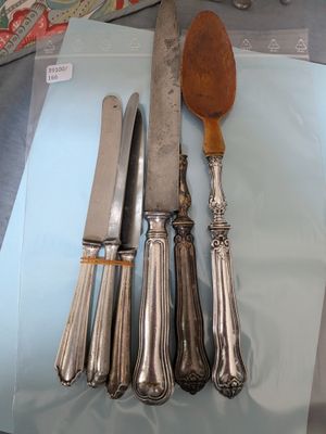 quatre couteaux et une cuillère posés sur une table