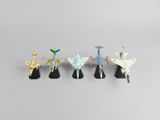 cinq avions en origami sont alignés sur une surface grise