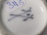 a close up of a white and blue vase with a sticker on it