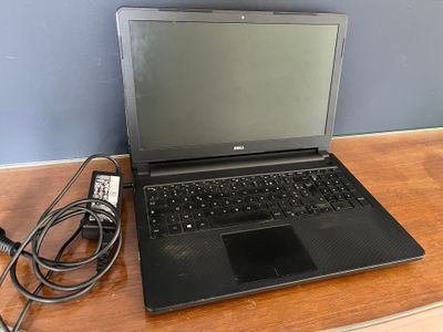 a laptop that is sitting on a desk with a charger