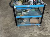 un chariot bleu sur lequel sont posés divers objets, dans un garage