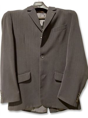 La veste est grise et comporte des boutons sur le revers.
