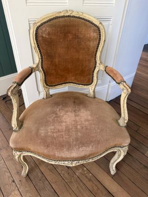 Une vieille chaise est posée sur un plancher en bois, près d'une porte.