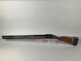 a shotgun with a wooden barrel and a black handle