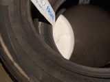 a tire with a sticker on it sitting on a pile of tires