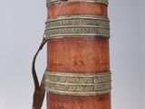 an old wooden and metal cylinder with a handle on a stand