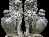paire de lions en pierre avec une urne et des vases sur fond noir