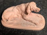 a statue of a dog that is sitting on a plate