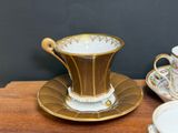 a cup and saucer sitting on a table next to a plate