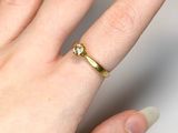 a woman ' s hand with a gold ring on it