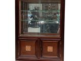 une vitrine avec une porte en verre et un socle en bois