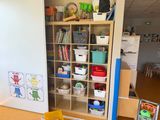 a book shelf with books and toys in the room