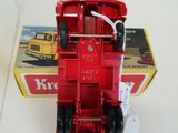 a red toy truck that is sitting in front of a box
