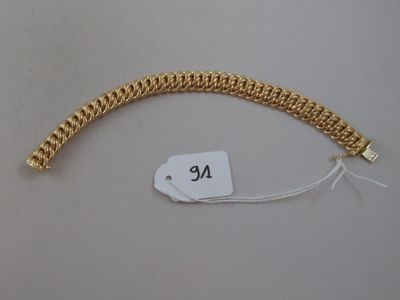 a close up of a gold bracelet with a tag on it