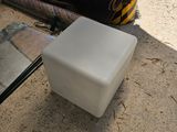 un cube blanc posé par terre à côté d'une cheminée