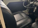 a black leather seat and steering wheel of a bus