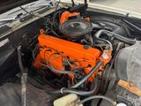 an orange engine in the engine bay of a car