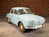 a blue car that is parked in front of a brick wall