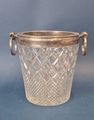 a glass vase with a metal handle on a blue background