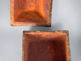 two small wooden boxes are sitting side by side on a gray surface