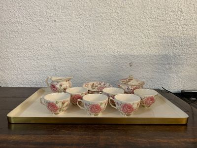 un plateau posé sur une table, sur lequel se trouvent des tasses et des soucoupes