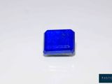 a close up of a blue square stone on a white surface