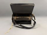 an image of a black purse with a gold handle on a white surface