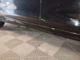 a black car that is parked on the side of the street