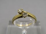 un gros plan d'une bague en or surmontée de deux diamants