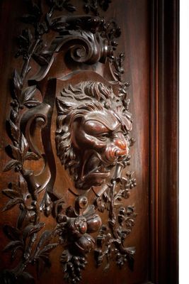 une image représentant une porte en bois sur laquelle est sculptée une tête de lion