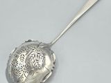 a silver spoon with a design on it on a white surface
