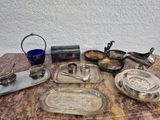 de nombreux objets en argent posés sur une table recouverte d'un verre bleu