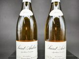 deux bouteilles de vin blanc posées sur une table noire