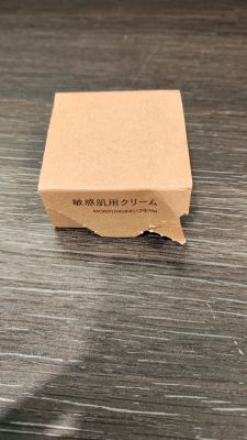 une petite boîte en carton posée sur une table, avec un petit bout de papier dessus