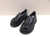 des chaussures à semelles compensées noires avec des semelles noires sur un fond blanc