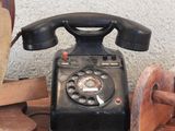 a black telephone sitting on top of a table next to a vase