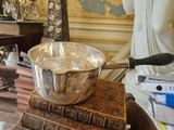 un bol en argent posé sur une pile de livres