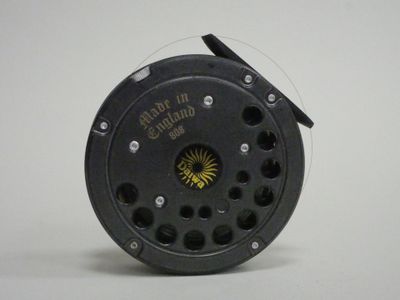a close up of a fishing reel on a white surface